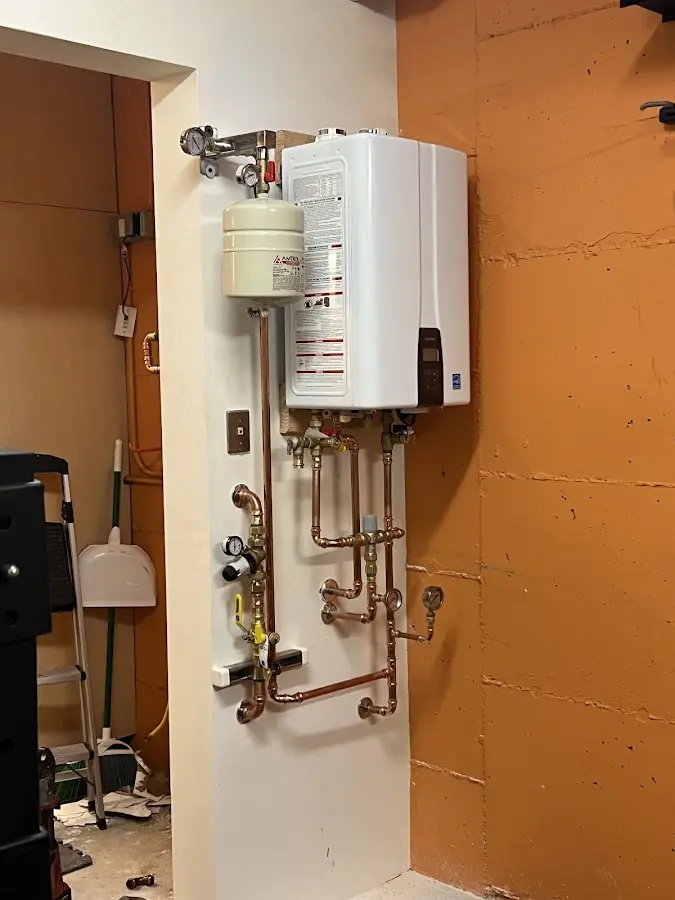 Plumbing technician inspecting water heater connections in Uvalde